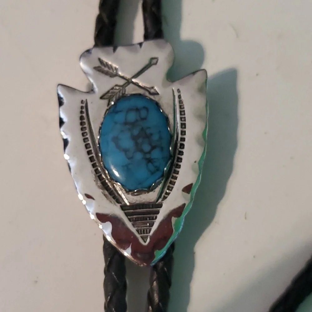 Western Bolo silver tone arrowhead with Turquoise syone on a black bread…